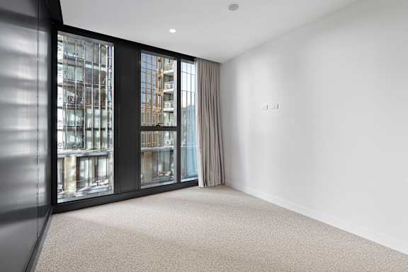 A room with a large window and a carpeted floor.