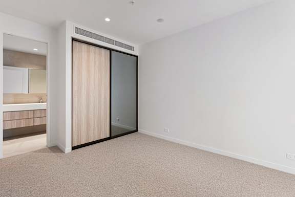 A room with a sliding door and carpeted floor.