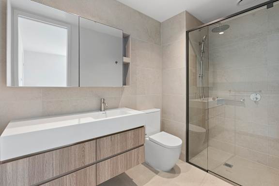 A modern bathroom with a white sink and a toilet.