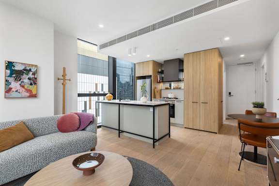 A modern living room with a grey couch and a wooden coffee table.