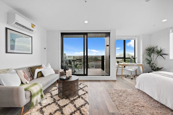 a living room with a couch and a chair and sliding glass doors