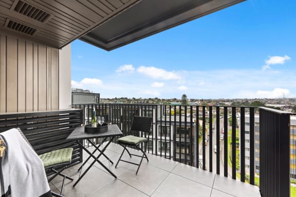 a balcony with a table and chairs and a view of the city