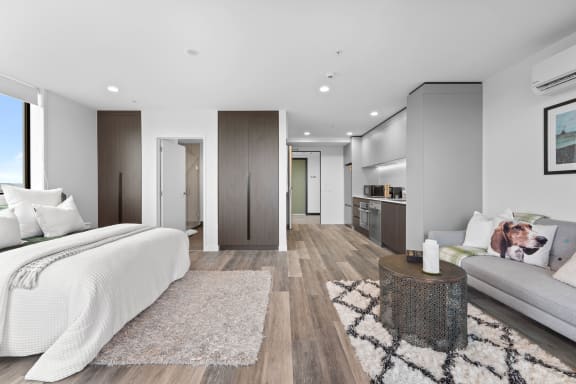 a bedroom with a bed and a couch and a living room