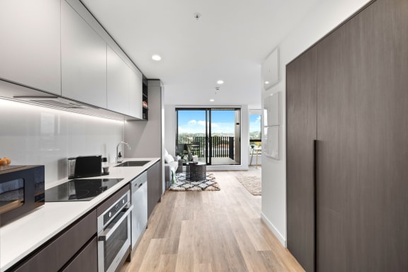 a kitchen with white cabinets and a door to a balcony