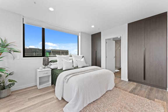 a white bedroom with a large bed and a window