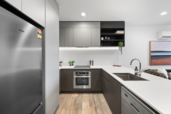 a modern kitchen with stainless steel appliances and white counter tops