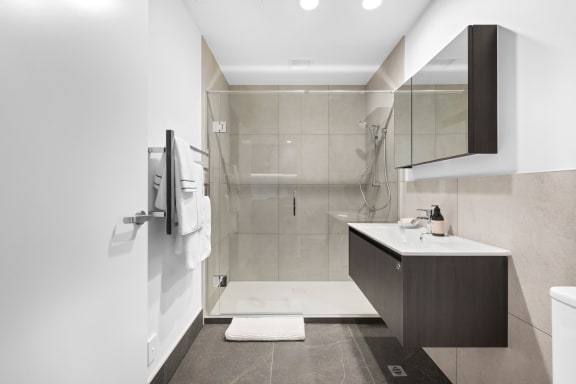 a white bathroom with a shower and a sink