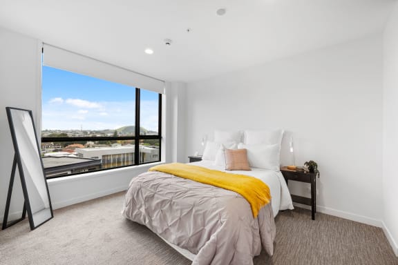 a bedroom with a bed and a large window