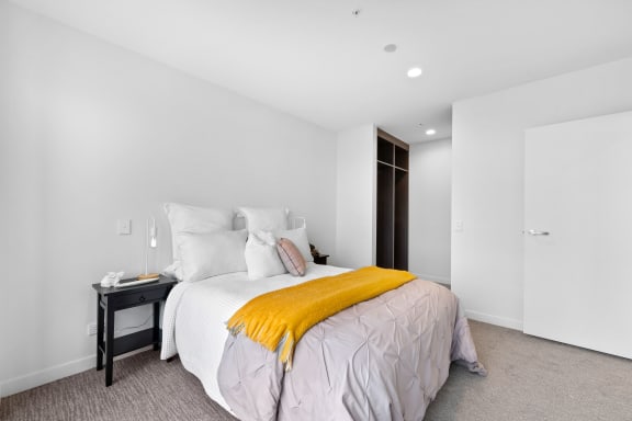 a bedroom with a large bed and a yellow blanket