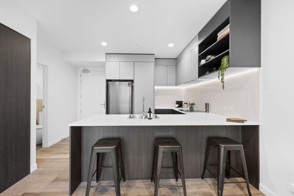a kitchen with a large island with three stools