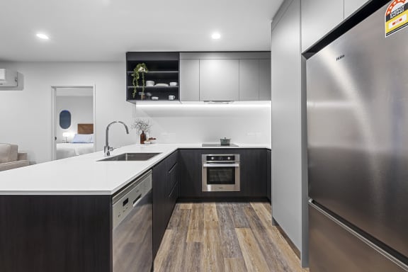 a kitchen with white countertops and stainless steel appliances