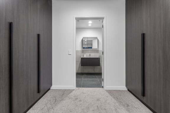 a view of a bathroom from a hallway with wooden doors