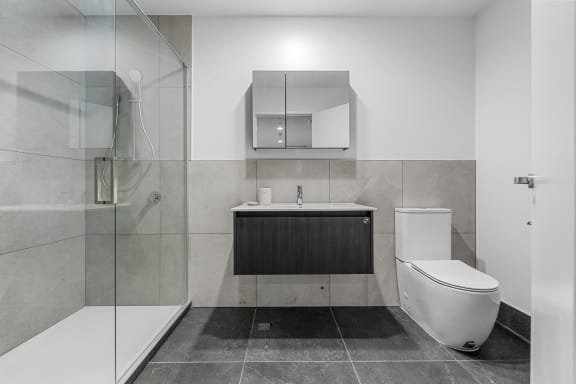 a bathroom with a toilet and a sink and a shower