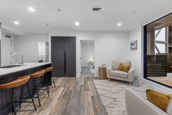 a living room with a couch and a kitchen with a sink