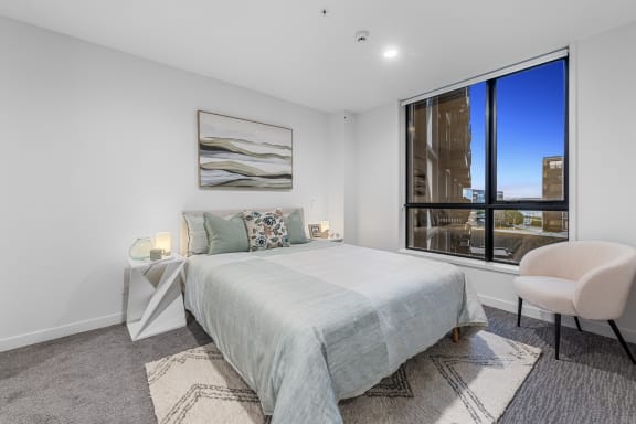 a bedroom with a large window and a bed