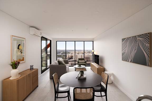 A modern dining room with a table set for four.