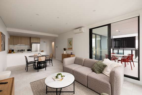 A modern living room with a grey sofa and a glass table.