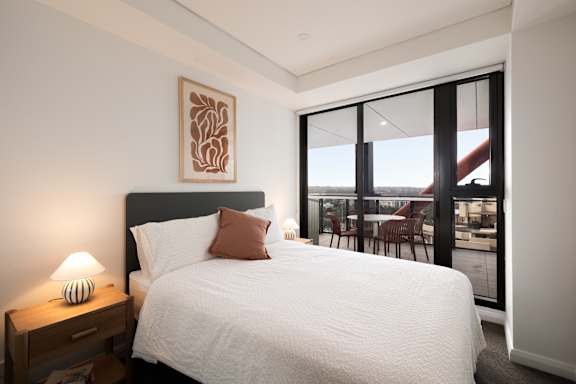 A bedroom with a large bed and a view of the outside.