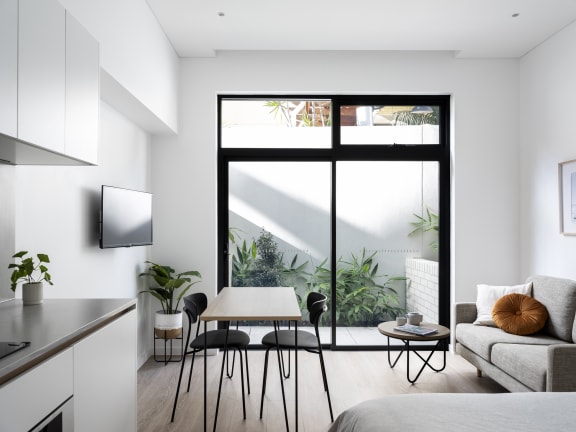 a living room with a kitchen and a large window