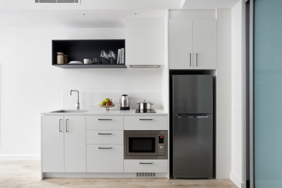 a kitchen with white cabinets and stainless steel appliances