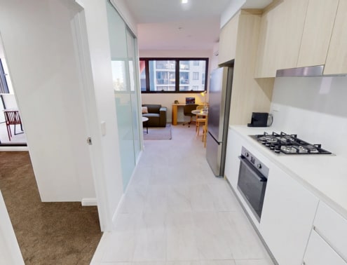 A kitchen with white cabinets and a stove top oven.