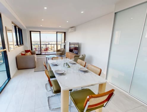 A dining room with a table set for six people.