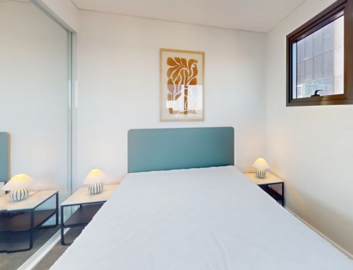 A bedroom with a large bed and two lamps.