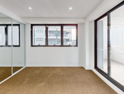 A room with a brown floor and white walls.