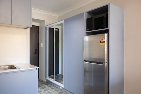 A modern kitchen with a refrigerator, sink, and microwave.