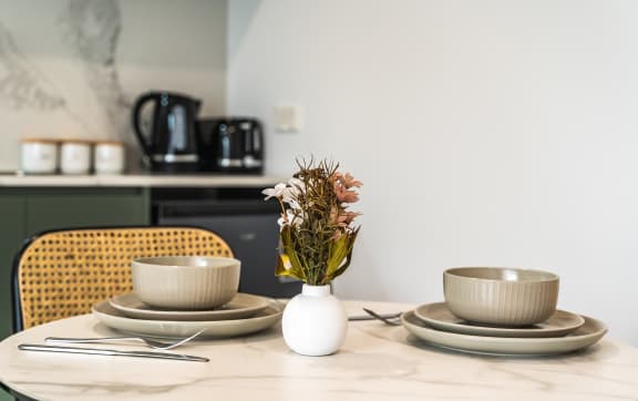 a table with plates and bowls and a vase with flowers on it