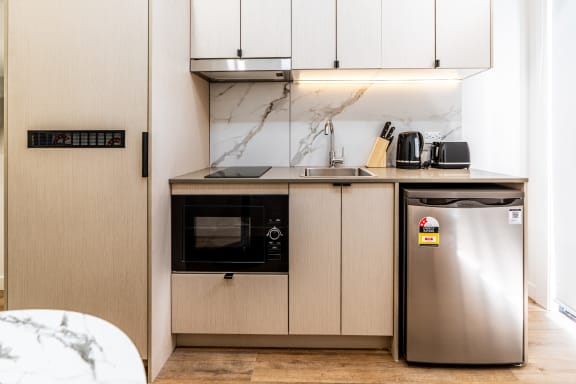 a small kitchen with a refrigerator and a microwave