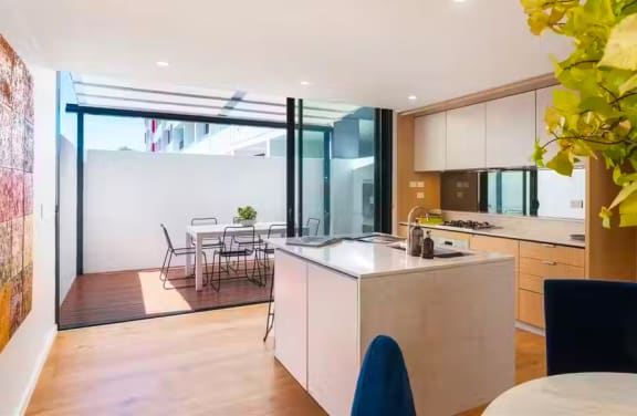 a kitchen and dining area in a modern house with glass doors