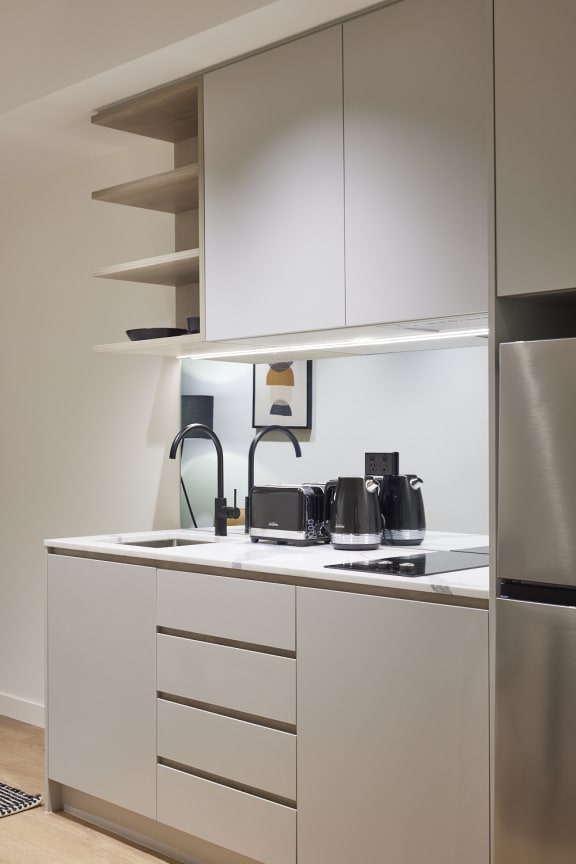 a kitchen with white cabinets and a stainless steel refrigerator