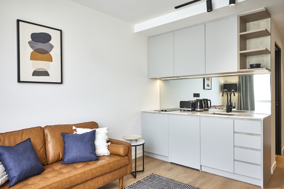 a living room with a couch and a kitchen in the background