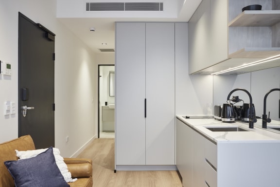 a kitchen and living room with white cabinets and a sink