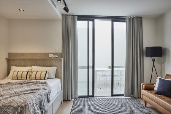 a bedroom with a bed and sliding glass doors