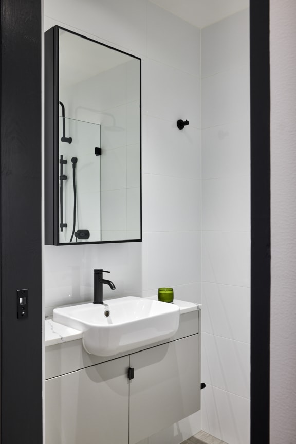 a small white bathroom with a sink and a mirror