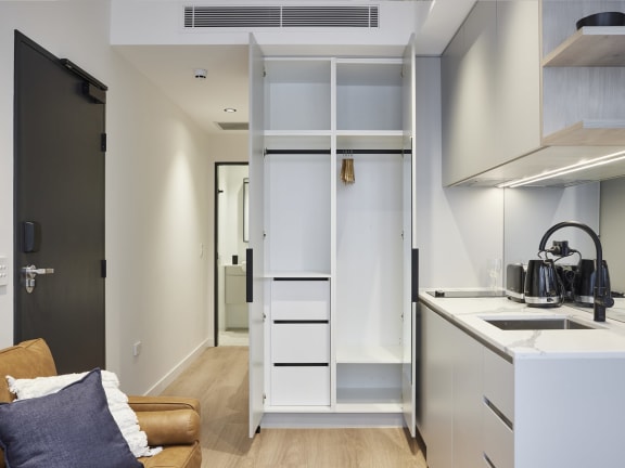 a kitchen with a refrigerator and a sink and a closet