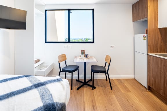 a bedroom with a bed and a table with two chairs