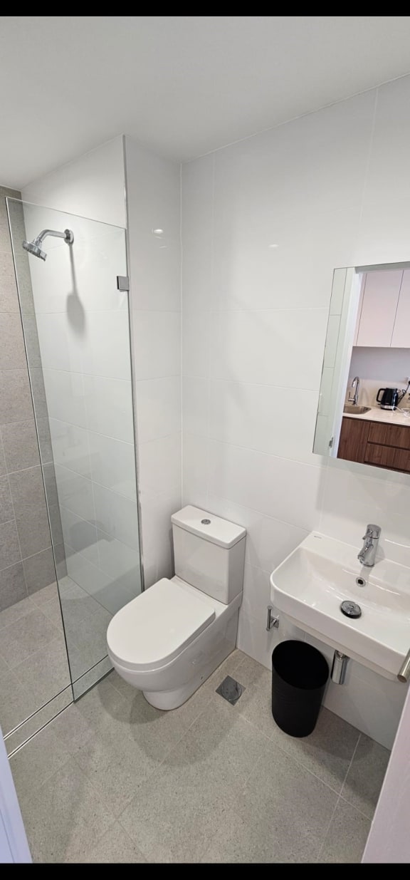 a white bathroom with a toilet and a shower