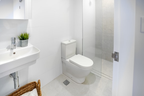 a white bathroom with a toilet and a sink