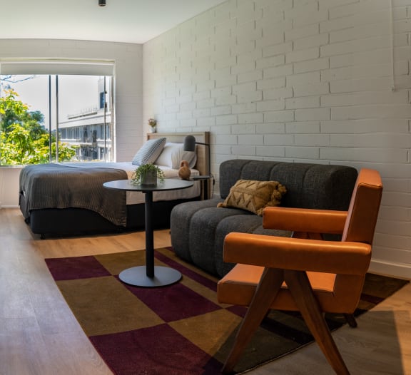 a living room with a couch and a table in front of a bed