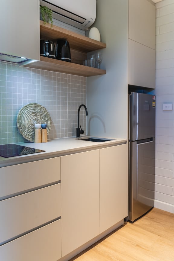 a kitchen with white cabinets and a sink and a refrigerator