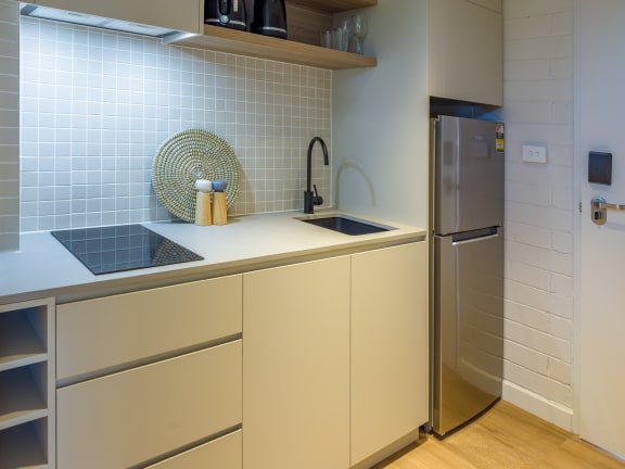 a kitchen with white cabinets and a sink and a refrigerator