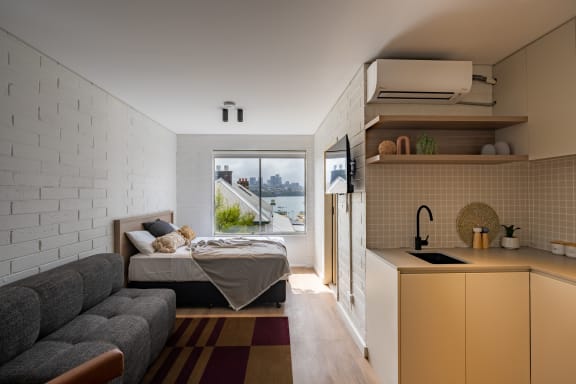 a studio apartment with a bed and a kitchen