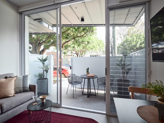 a living room with a couch and a table and a balcony