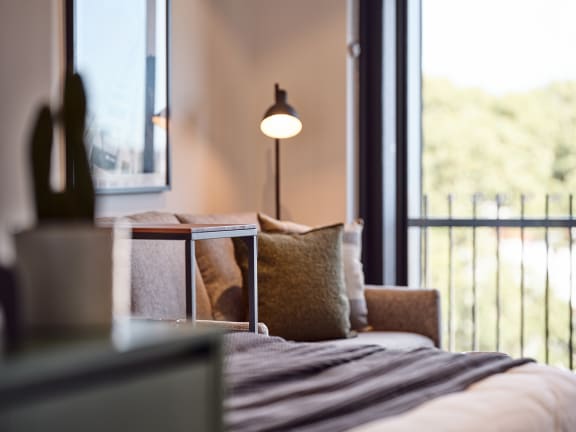 a bed with pillows in a room with a window