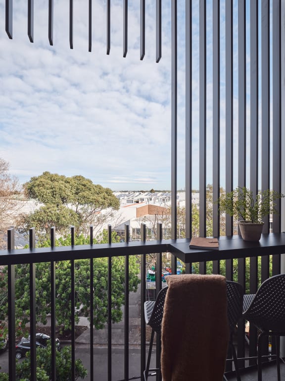 a balcony with a table and chairs and a view of the city