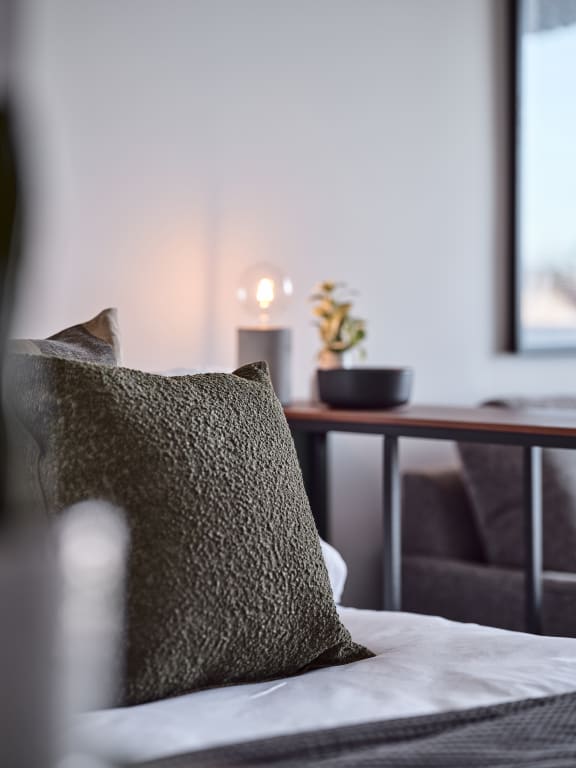 a bed with a pillow and a table in the background