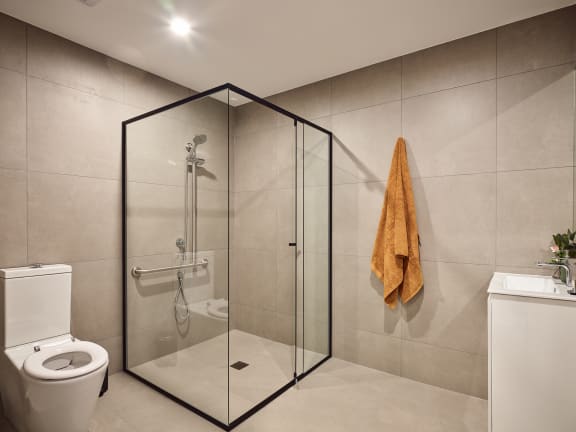 a bathroom with a shower and a toilet and a towel